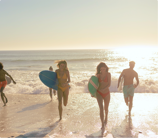 People on a beach with surfboards and swimsuits